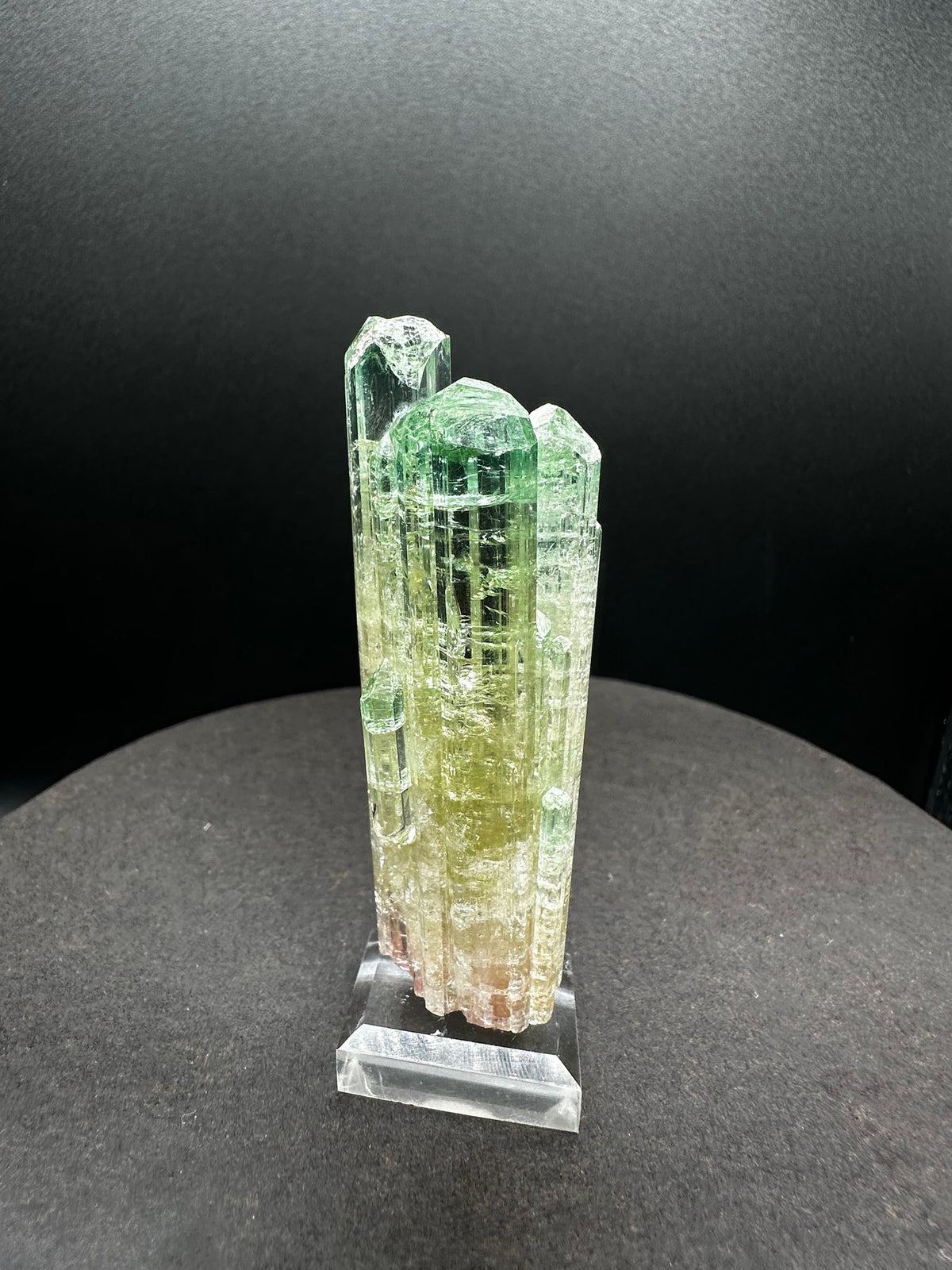Multi-column watermelon tourmaline cluster in green, yellow and pink, on a stand, Pakistan, reverse side
